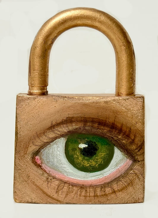 A padlock, featuring an eye painted on it using oil paint and spray paint.